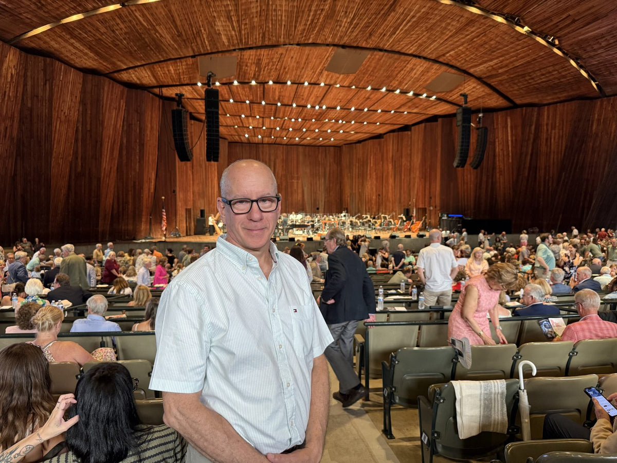 Doug, a Legato customer, wearing his Legato glasses at a concert hall